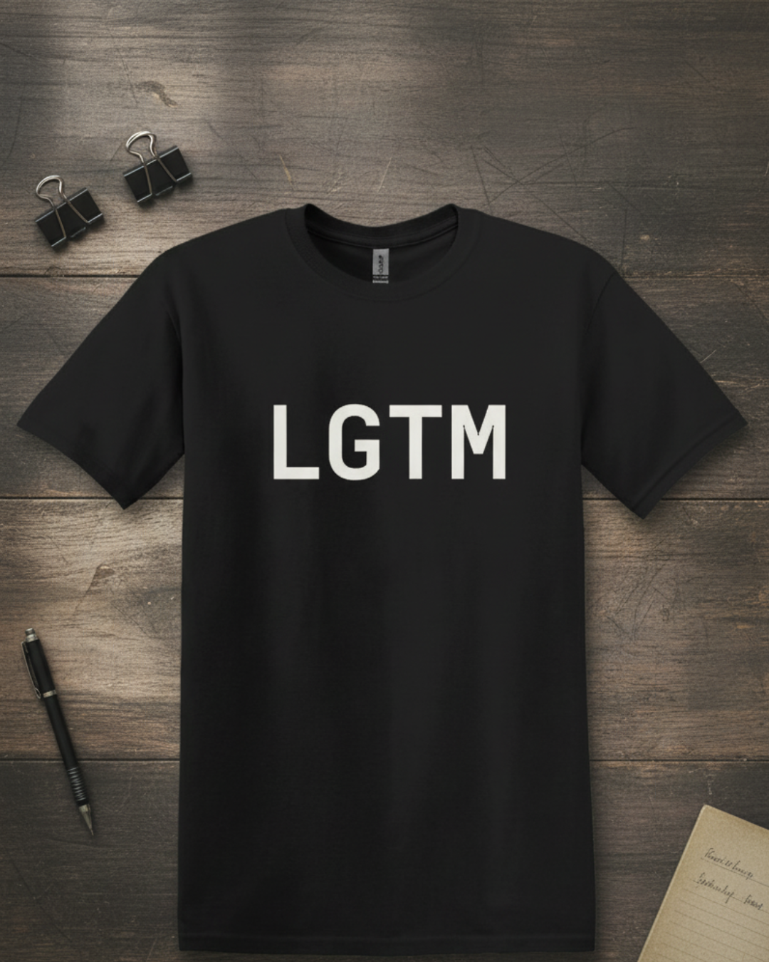 Black t-shirt with 'LGTM' text on a wooden surface