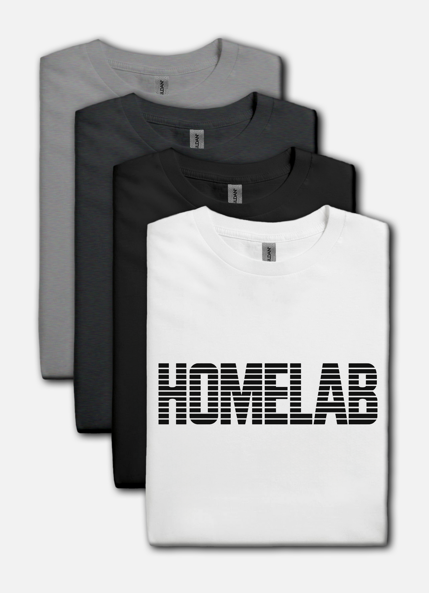 White t-shirt laid in a row featuring a bold black “HOMELAB” wordmark with horizontal stripe/scanline effect; retro computer aesthetic with soft natural shadows.