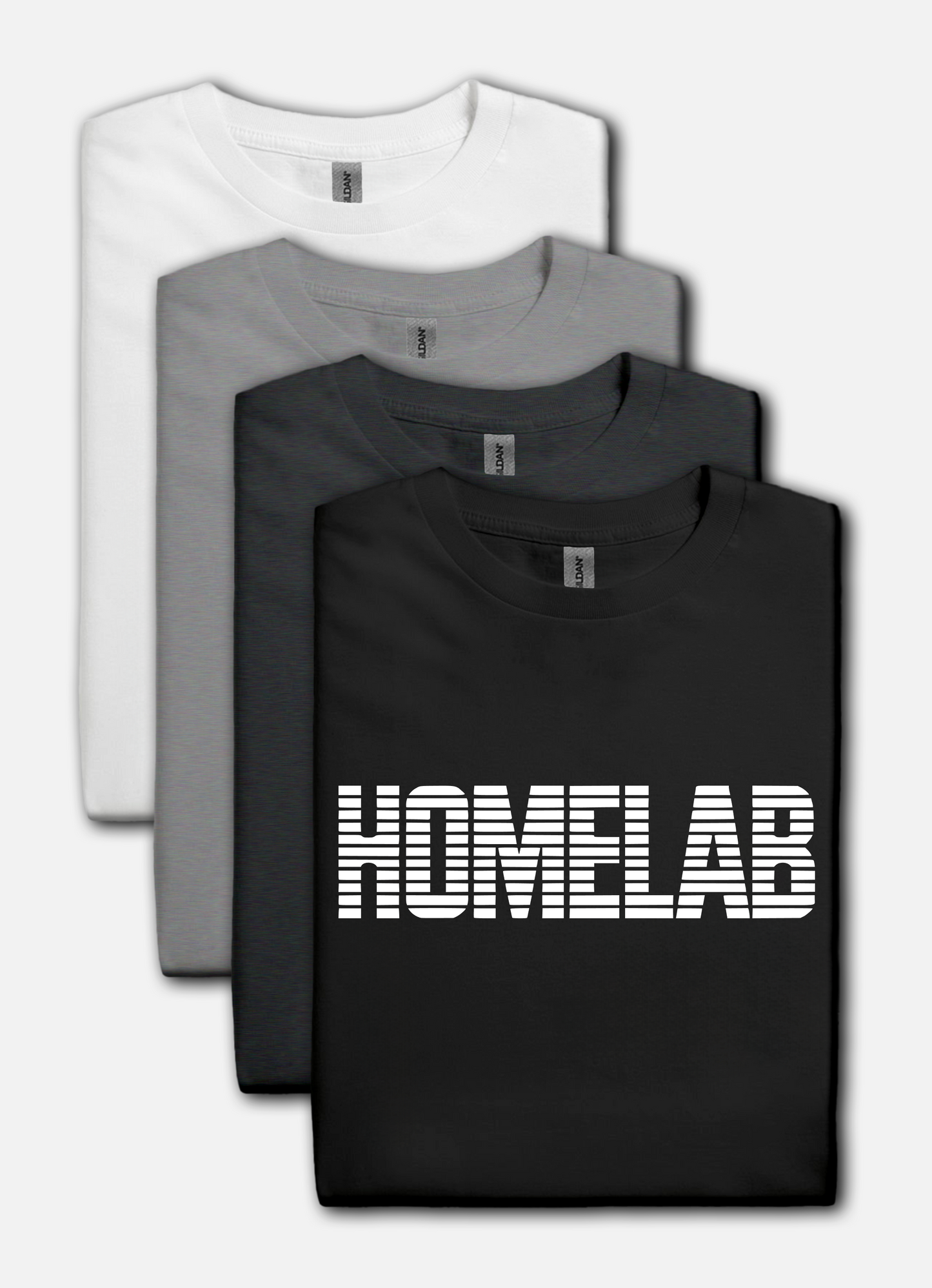 Black t-shirt laid in a row featuring a bold white “HOMELAB” wordmark with horizontal stripe/scanline effect; retro computer aesthetic with soft natural shadows.