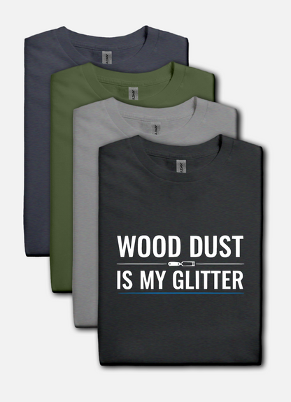 Dark heather t-shirt with bold white text that reads “Wood Dust Is My Glitter,” minimal graphic design.
